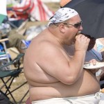 Fat shirtless guy eating a cheeseburger Fat shirtless guy eating a cheeseburger